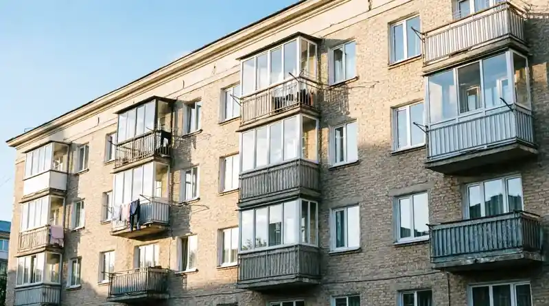 Балкон в многоквартирном доме: вид снаружи на фасад здания с балконами и лоджиями